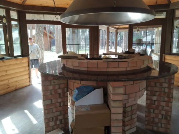 Каменная столешница для круглого мангала в застеклённой беседке